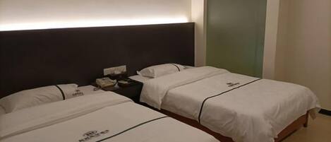 A hotel room with two beds, a nightstand, and a wall-mounted artwork.