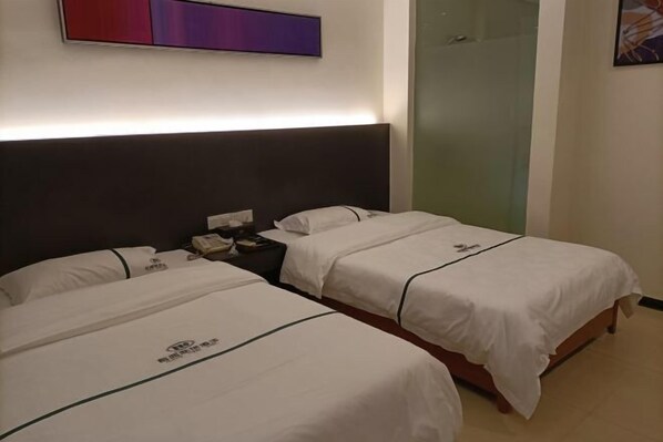 A hotel room with two beds, a nightstand, and a wall-mounted artwork. - Ming Tien Inn (Fengkai)