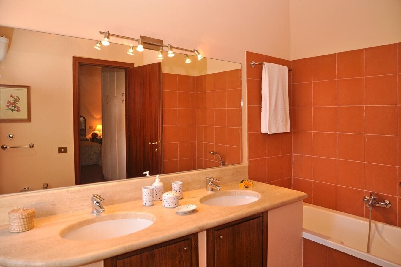A bathroom with two sinks, a large mirror, and a bathtub.