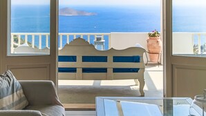 Ein Balkon mit einer weißen Bank, einem Blumentopf und Blick aufs Meer.