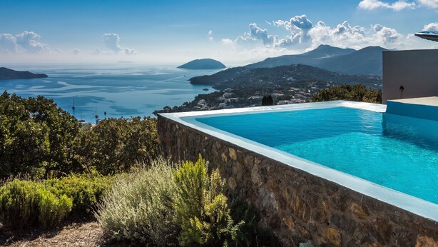 Ein Schwimmbad mit Blick auf das Meer und die Berge.