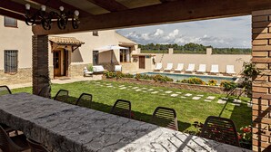 A covered patio with a pool, outdoor seating, and a stone table. - Spectacular house nestled among vineyards, less than 1 hour from Barcelona (Sant Marti Sarroca)