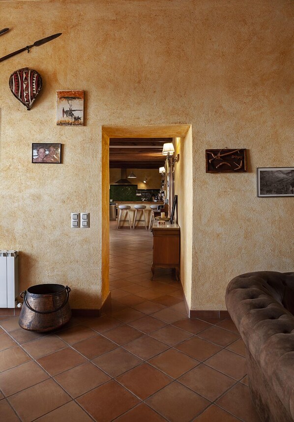Una sala de estar acogedora con chimenea, un comedor y una cocina visibles a través de un vano abierto.