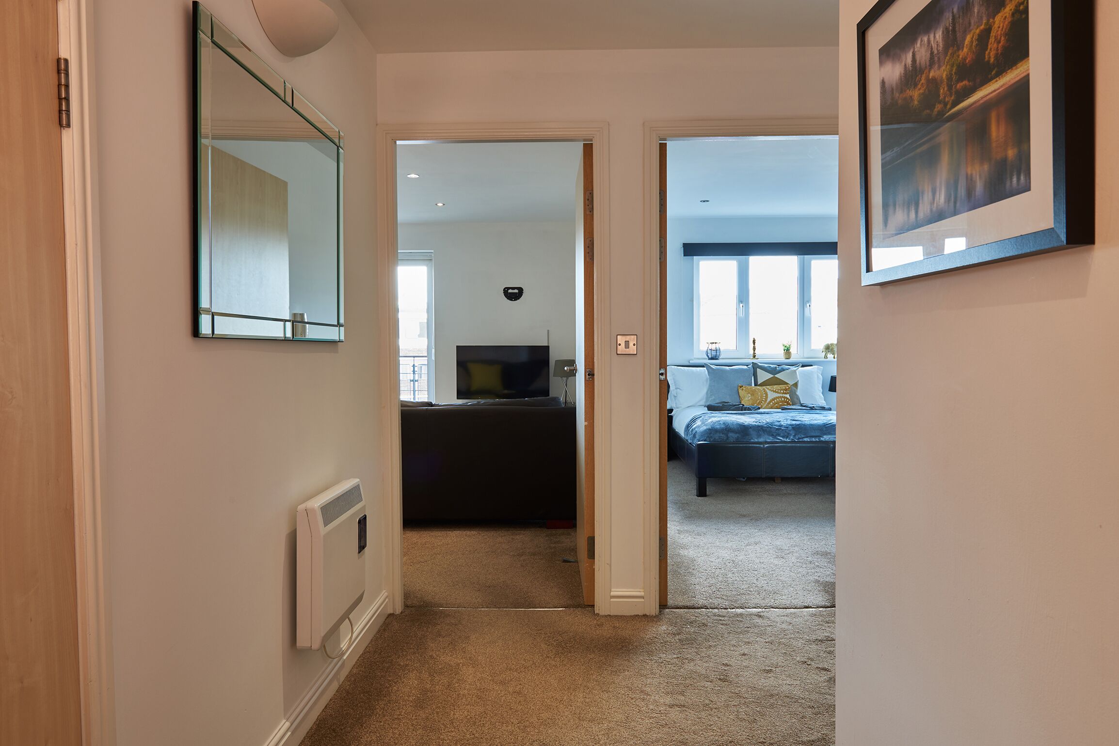 A hallway leading to a living room with a sofa and a TV.