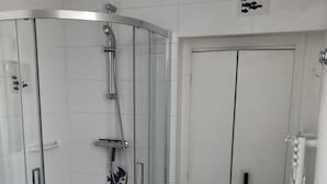 A bathroom with a glass-enclosed shower, a toilet, and a sink. - House with garden (Saint-Malo)