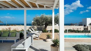 A covered outdoor area with lounge chairs and a pool, overlooking the sea. - Marza Residence – Rosa, with private pool (Reitani)