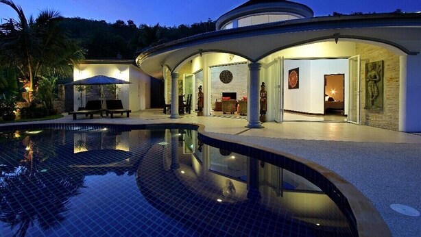 Un complexe hôtelier de luxe doté d’une piscine, d’un espace extérieur aménagé et couvert, et d’un intérieur bien éclairé.