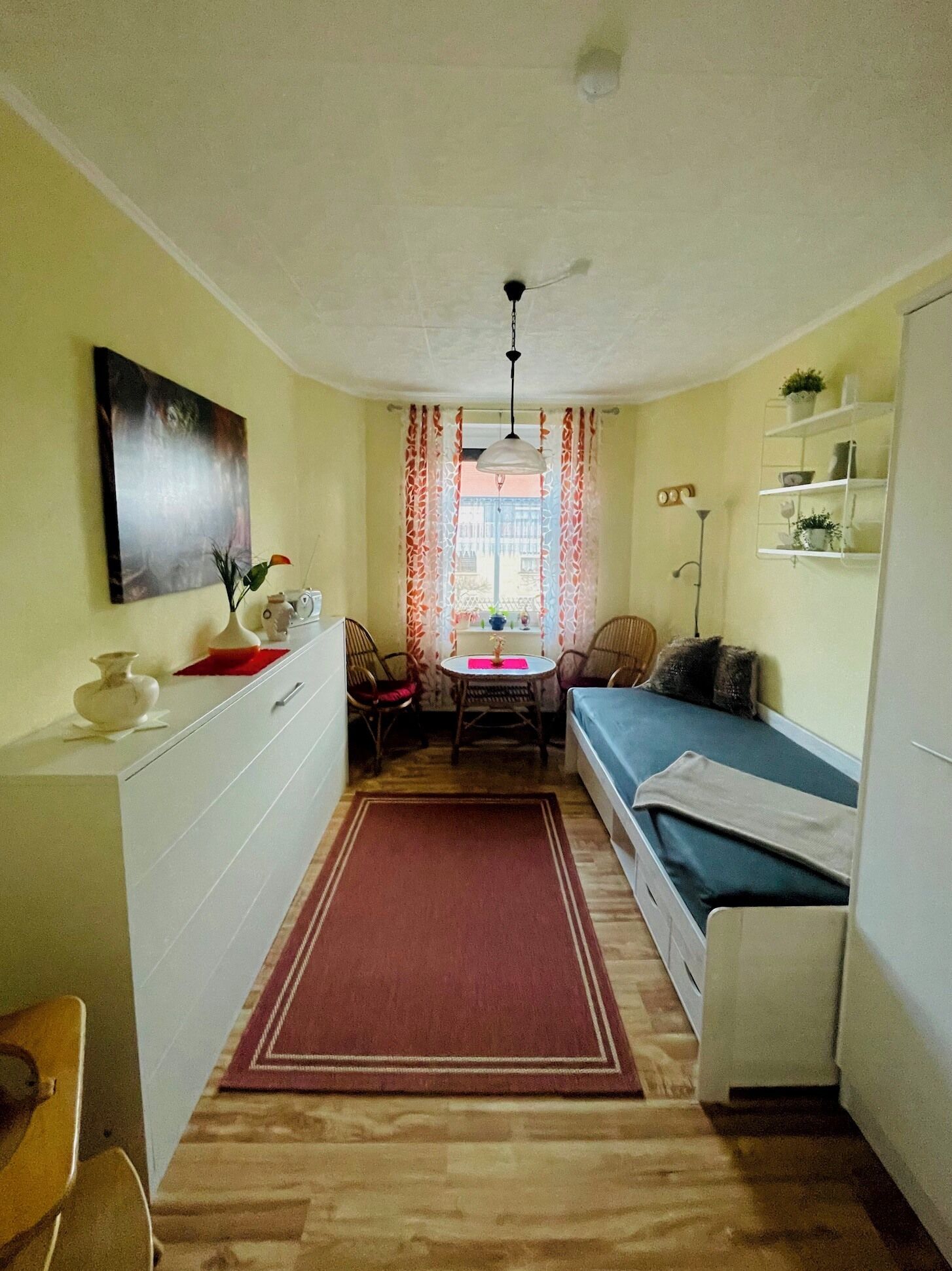 En kompakt bolig med tekøkken, spiseplads og seng.