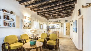 Una sala de estar acogedora con muebles de mimbre, una mesa de madera y una estantería.