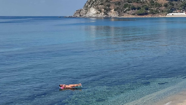 A clear beach with calm waters and a rocky hillside in the background. - villas just by the sea (Santa Maria di Ricadi)