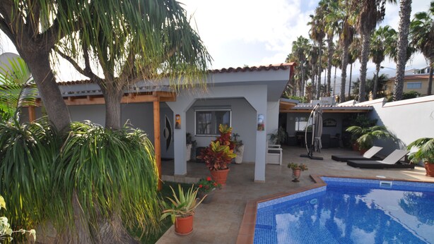 A poolside area with a tiled pool, potted plants, and a patio with a table and chairs. - Luxury villa with heated pool in Puerto de la Cruz (Puerto de la Cruz)