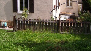Un bâtiment à deux étages, avec une façade de couleur beige et des volets foncés.