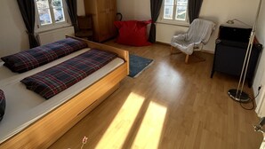 Une chambre à coucher comprenant un lit, une armoire, une chaise, un bureau et un radiateur.