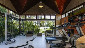 A gym with treadmills, dumbbells, and exercise equipment.