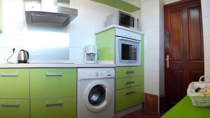 A compact kitchen with a washing machine, a microwave, and a coffee maker on the countertop. - Modern Oceanfront Penthouse Apartment. Very Spacious. Big Sunbathing Terrace. (El Medano)