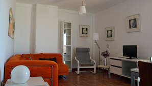 A modern living room with a sofa, armchair, and a desk with a computer. - Modern Oceanfront Penthouse Apartment. Very Spacious. Big Sunbathing Terrace. (El Medano)