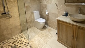 Une salle de bain avec une douche à parois de verre, des toilettes et un lavabo doté d’un grand bac.