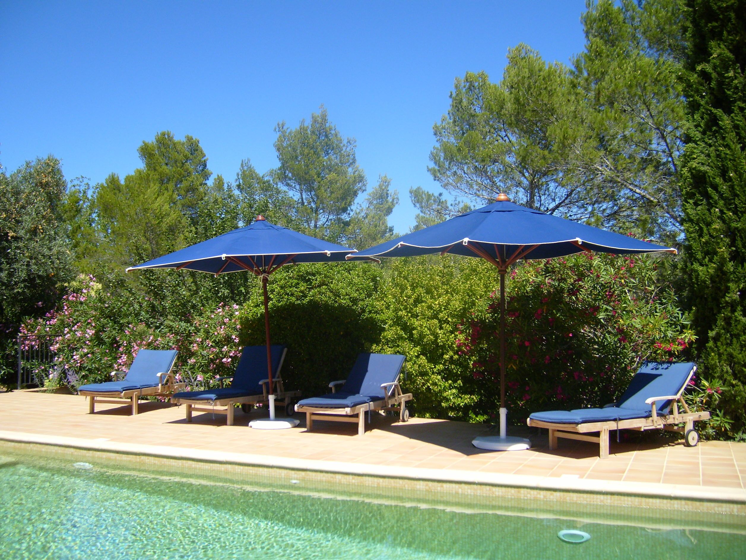 A poolside area with lounge chairs and umbrellas.