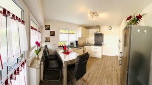 A compact kitchen with a refrigerator, microwave, and wooden countertop.