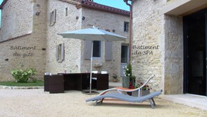 Ein Steinhaus mit Wellness- und Fitnessbereich, inklusive Außenbereich mit Sitzgelegenheiten und Liegestuhl.