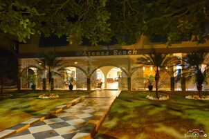 Un patio con un sendero a cuadros que conduce a una entrada con la leyenda 'Arenas Beach'.