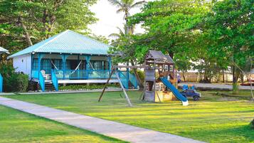 Stroll through the lush gardens to this charming home, featuring a porch and a separate playhouse with a slide.