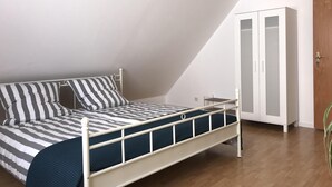 A bedroom with a bed, a wardrobe, and a plant. - new in 2019 !! Our apartment has been lovingly furnished for you (Minderlittgen)