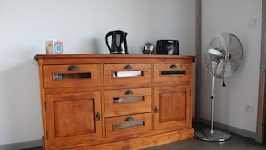 Un meuble en bois avec des tiroirs et une bouilloire posée sur le dessus.