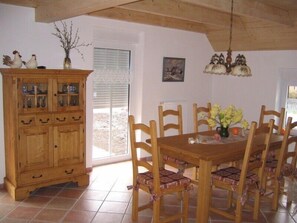 Enjoy meals in this dining area with a wooden table and six chairs, a cabinet, and a chandelier.