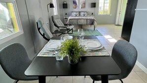 A dining area with a table set for four, a sofa, and a bed in the background. - Sun, beach, and great deals—discover dream vacation destinations with discounts (Matlacha)