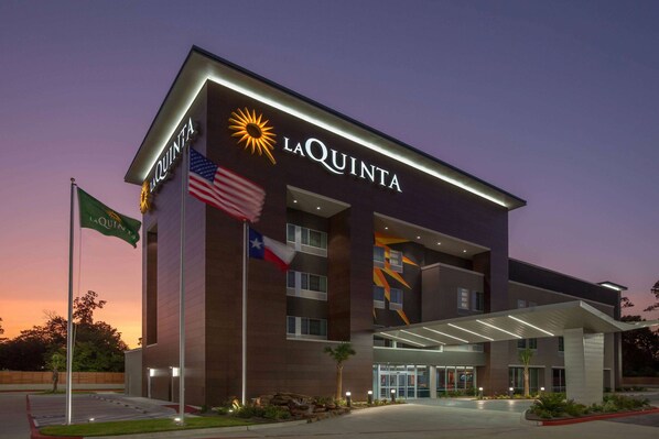 Ett modernt hotell med en tydlig skylt med texten ”La Quinta”, flera våningar och en ingång som är skyddad från väder och vind.