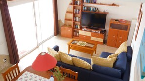 A living room with a sofa, coffee table, and TV. There is a bookshelf and a cabinet. - Spacious house with 3 bedrooms, 2 bathrooms, swimming pool (Costa Calma)