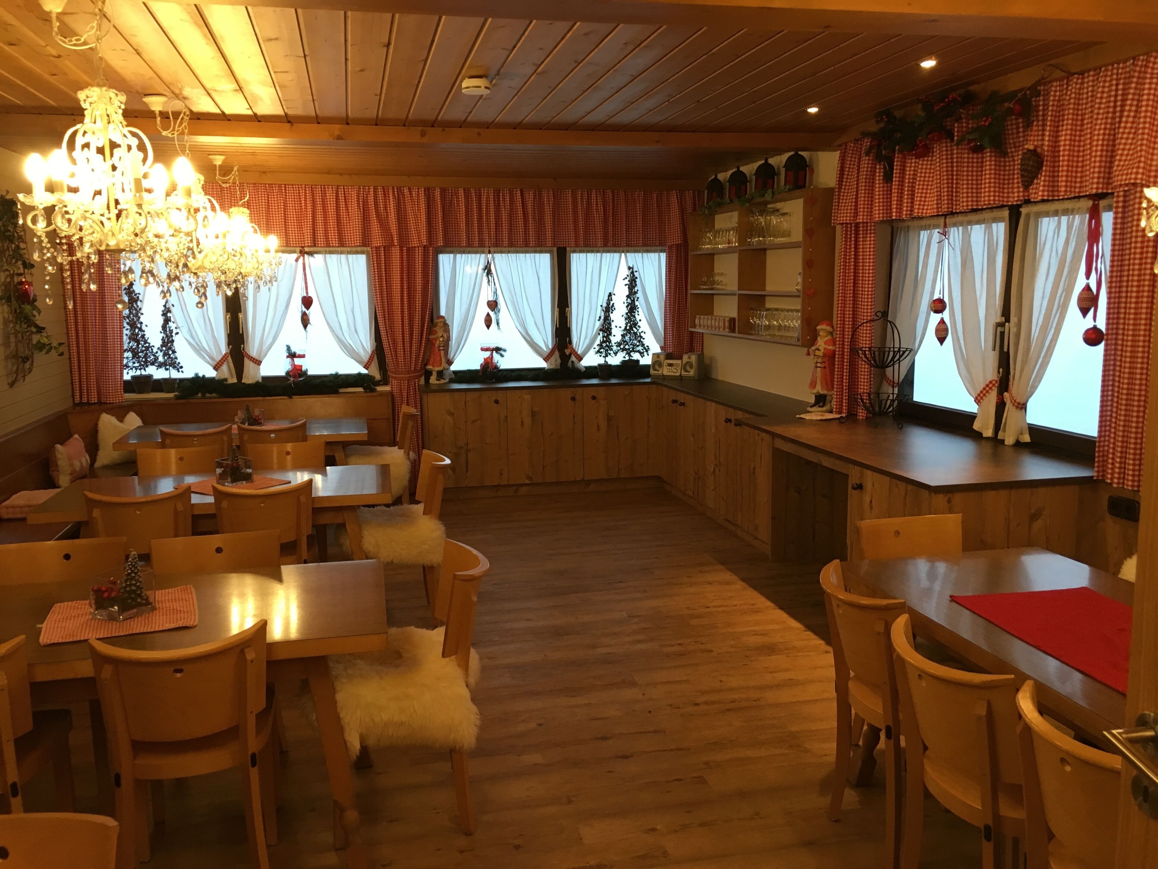Un restaurant chaleureux, avec des meubles en bois, un lustre et des décorations festives.