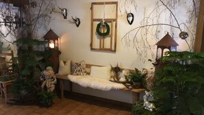 A cozy living room with a wooden bench, a fireplace, and various decorative items including a wreath and antlers. - comfortable (Riefensberg)