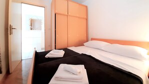 Ein Schlafzimmer mit Bett, Kleiderschrank und Tür.