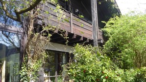 A modern building with a wooden balcony, surrounded by lush greenery and a small wooden deck. - Romantic Black Forest house, enchanted garden, half-timbered town of Schiltach  (Schiltach)
