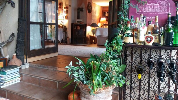 A cozy living room with a fireplace, a bookshelf, and a wine rack with bottles. - Romantic Black Forest house, enchanted garden, half-timbered town of Schiltach  (Schiltach)