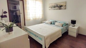 Une chambre à coucher avec un lit, une table de chevet, une lampe et un tableau au mur.