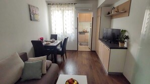 Un espace de vie compact comprenant un coin repas, une kitchenette et un canapé.