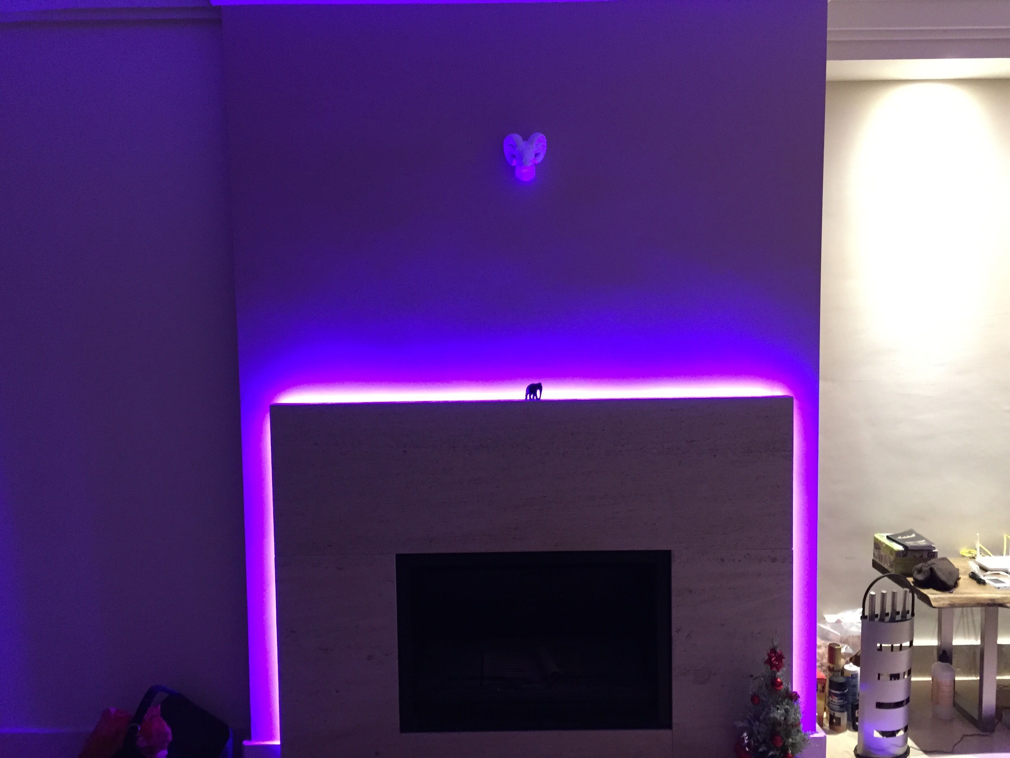 A room with a fireplace, a small table with items, and a wall-mounted TV.