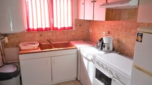 A compact kitchen with a sink, stove, and a coffee maker. - Gîte for 5 to 7 people in Sarlat. Heated swimming pool. Wifi. >>Nature (SARLAT LA CANEDA)