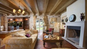 A spacious living room with a fireplace, a wooden ceiling, and a cozy seating area. - First class luxury villa with big pool, 1000sqm living area, 30000 sqm garden (porec)