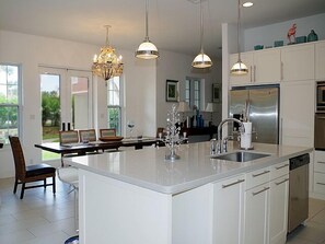 Enjoy cooking in this well-equipped kitchen with a central island, sink, and dishwasher, surrounded by ample cabinetry.