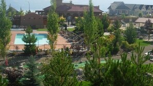 A resort with a swimming pool, lounge chairs, and a mountainous backdrop. - Luxury Modern Lake Cottage, Huge Deck Sleeps 8, Pet Friendly, Close to Amenities (Kelowna)