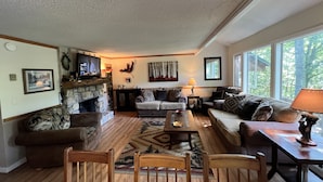 A cozy living room with a fireplace, a sofa, a coffee table, and a TV. - 'Nob Nest' - Perfect location, Close to Everything (Sugar Mountain)