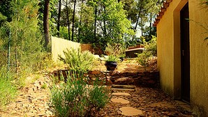 A stone pathway leading to a rustic building with a tiled roof, surrounded by greenery and trees. - Charming cottages, private SPA and private garden (Bédoin)