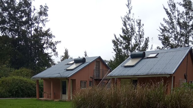 Een huis met twee verdiepingen, een plat dak en een klein balkon op de bovenverdieping.