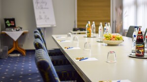 A conference room with a long table, chairs, a whiteboard, and a bowl of fruit. - Alte Mühle (Roedental)