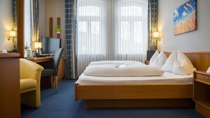 A hotel room with a large bed, a desk with a computer, a chair, and a TV. - Alte Mühle (Roedental)