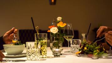 A dining table with various dishes, glasses, and a candle.